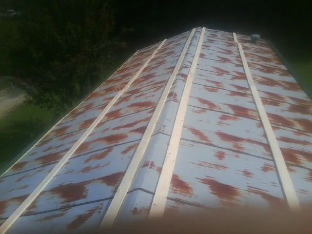 Rusted metal roof panels with new wood purlins before replacement — Storm Damage Roof Repair in Hinton by Roofing Brothers