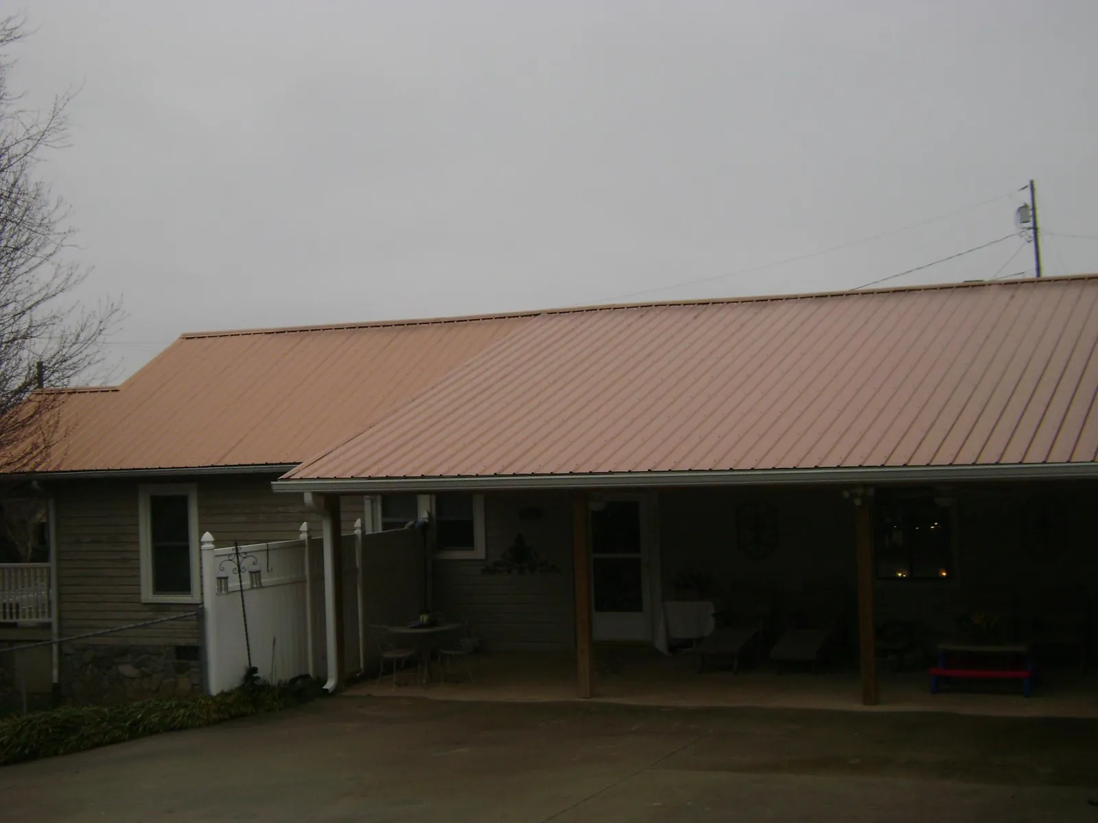 Copper toned metal roof over a wide covered patio in Hinton